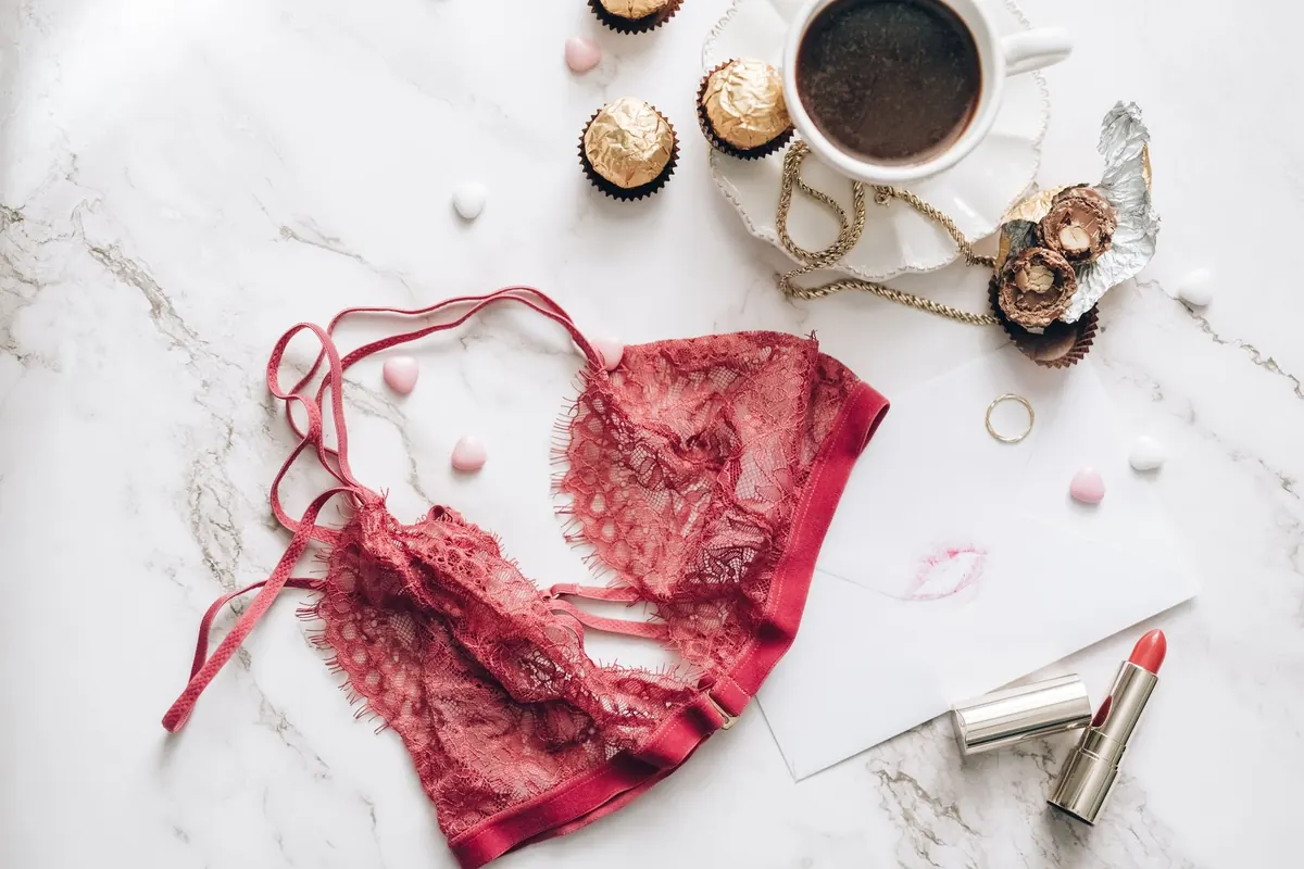 Bralette rouge, café et rouge à lèvres, en illustration de « strings souillés »