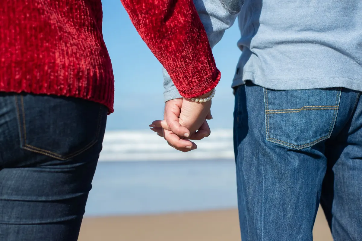 Promenade main dans la main sur la plage, en illustration de « confessions d'une vendeuse de culottes »