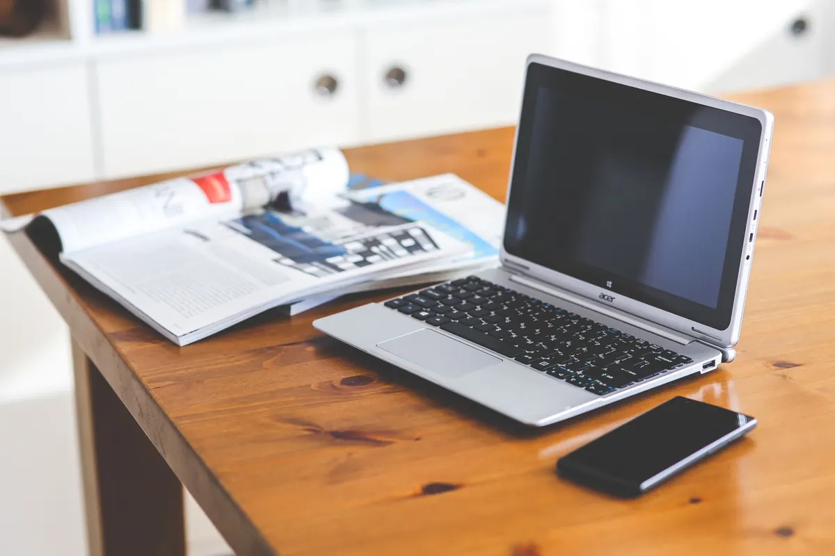 Ordinateur portable et magazine, en illustration de « vpn travail du sexe »