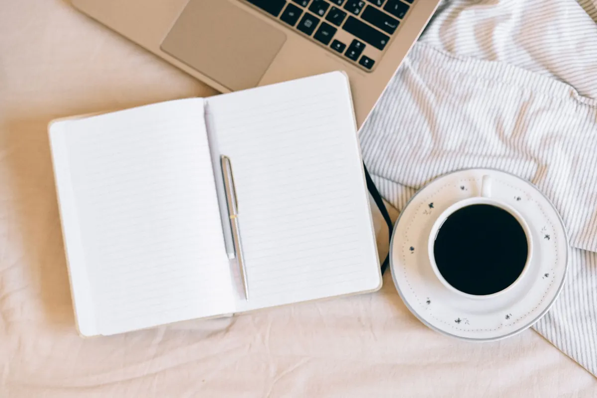 Carnet, café et ordinateur sur le lit, en illustration de « acheteur de culottes et dépression »