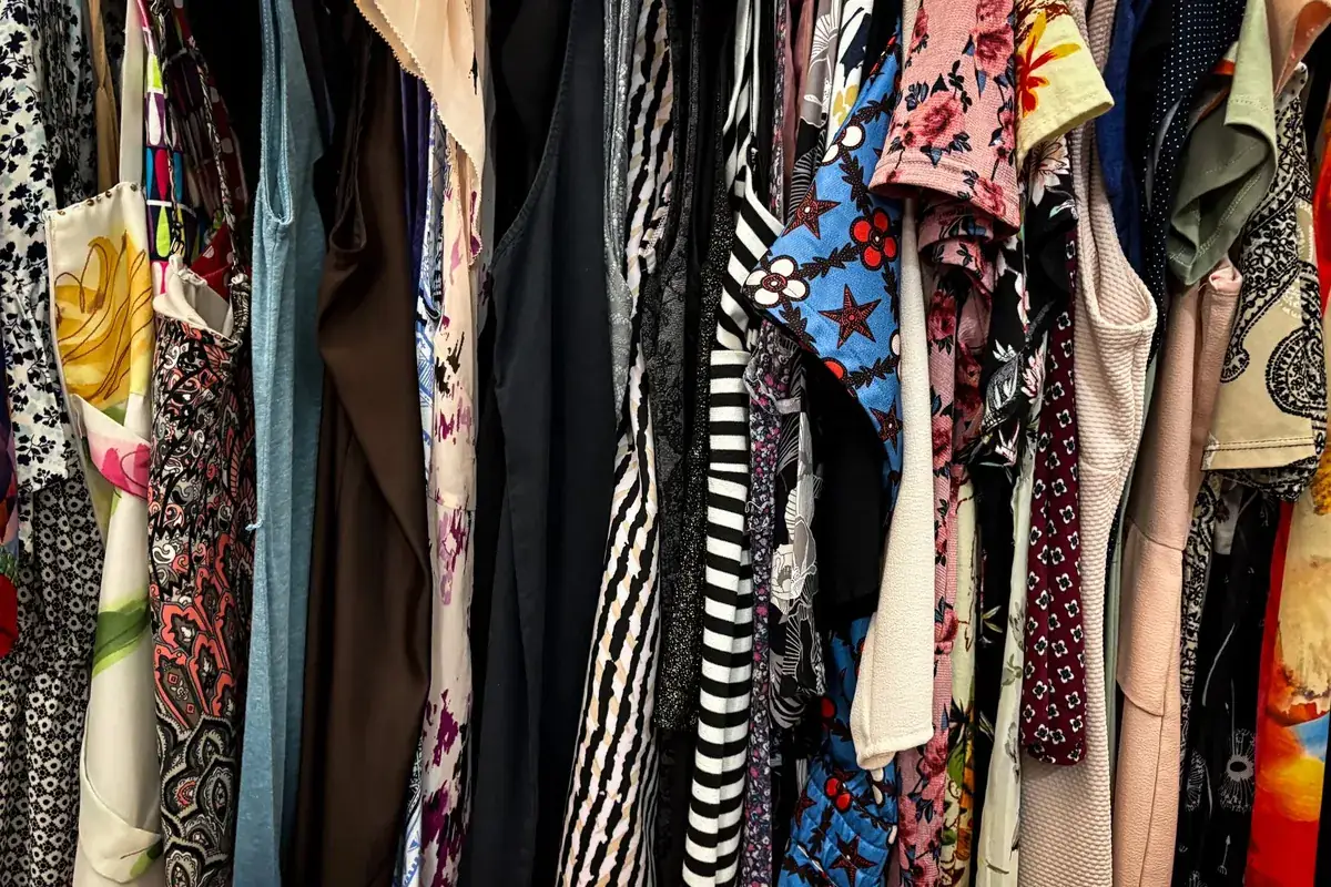 Vêtements à motifs sur des cintres, en illustration de « coulisses de la vente d'articles portés »
