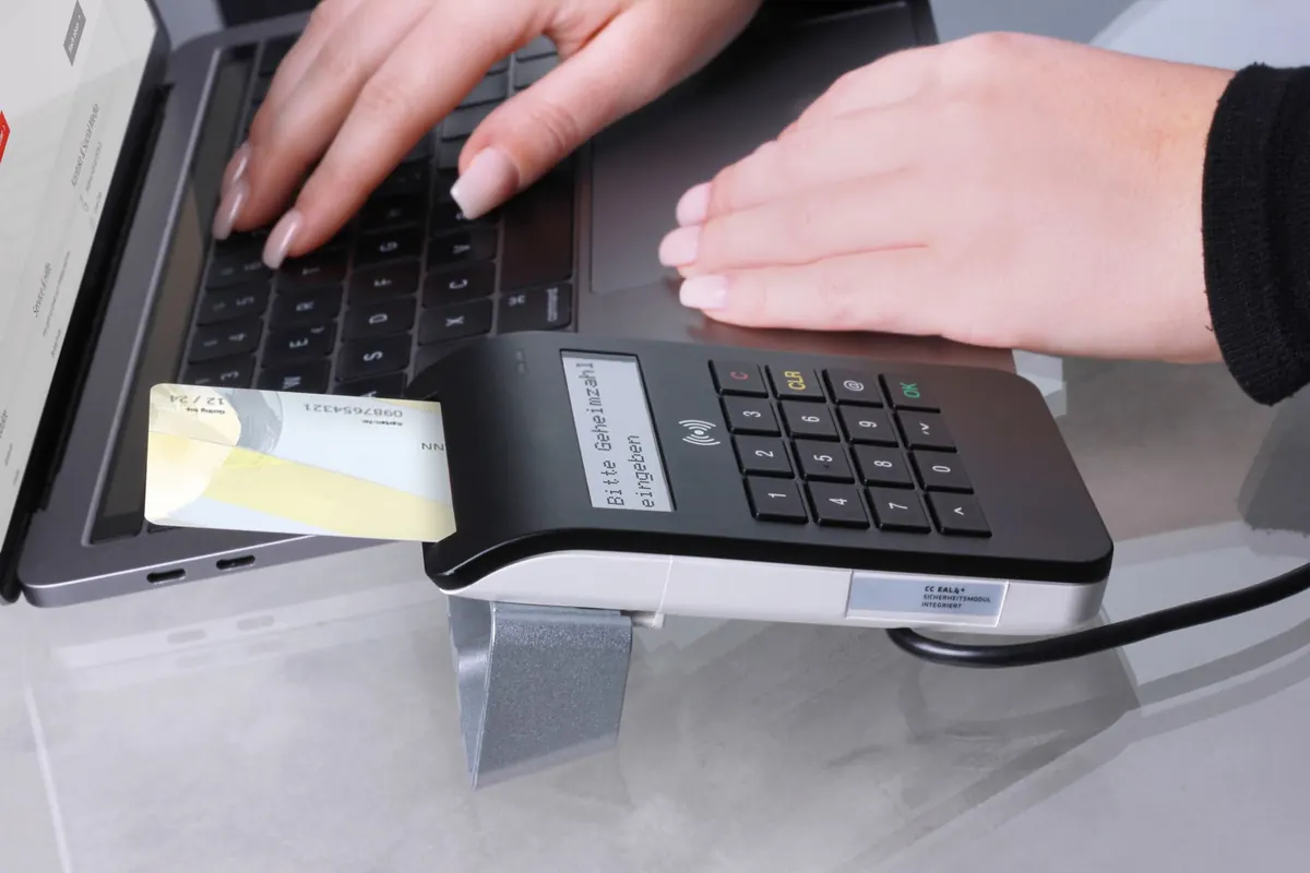 Paiement par carte sur un terminal près d'un ordinateur, en illustration de « débuter dans la vente de culottes »