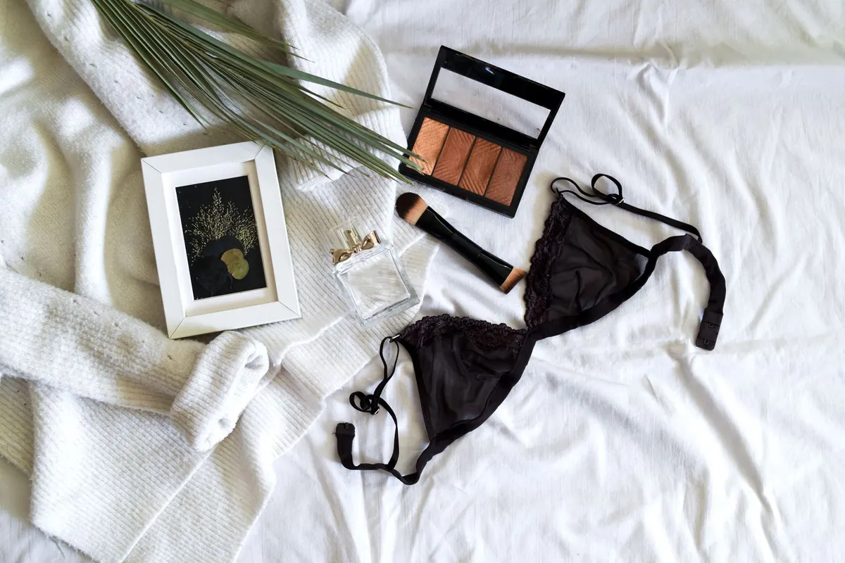 Lingerie noire et maquillage sur un drap blanc, en illustration de « moyens de paiement vente de culottes »