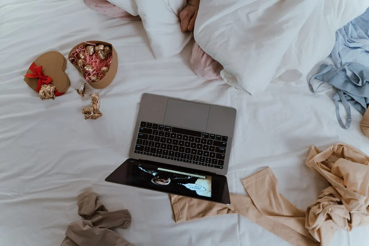 Ordinateur et fleurs sur un lit, en illustration de « vendeur de culottes neurodivergent »