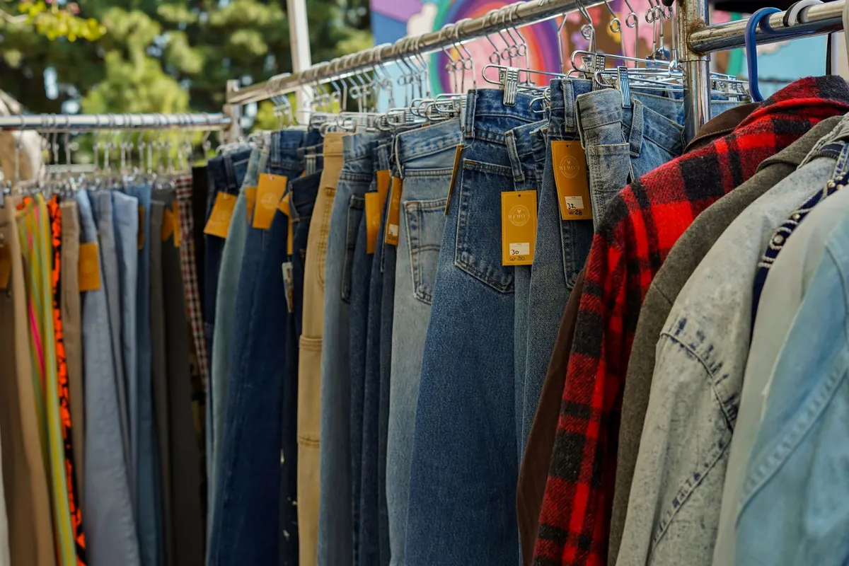 Portants de jeans et de chemises, en illustration de « vendre des articles portés sur Etsy ou eBay »