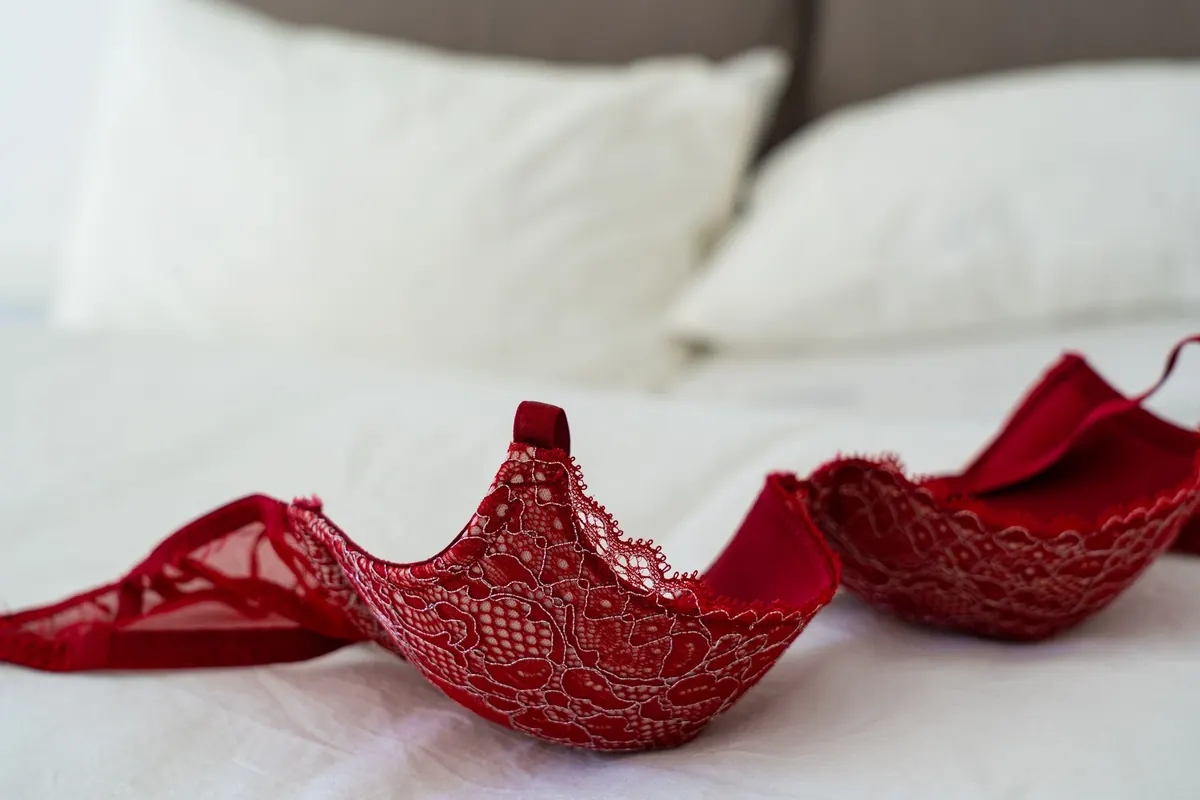 Soutien-gorge rouge sur un lit, en illustration de « vendre des culottes à temps plein »