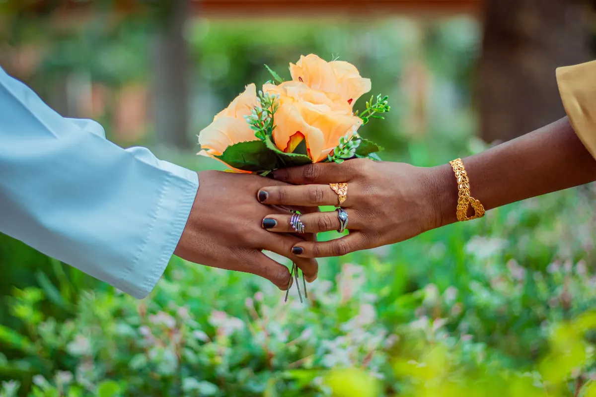 Mains jointes et bouquet de fleurs, en illustration de « ce que les vendeuses attendent des acheteurs »
