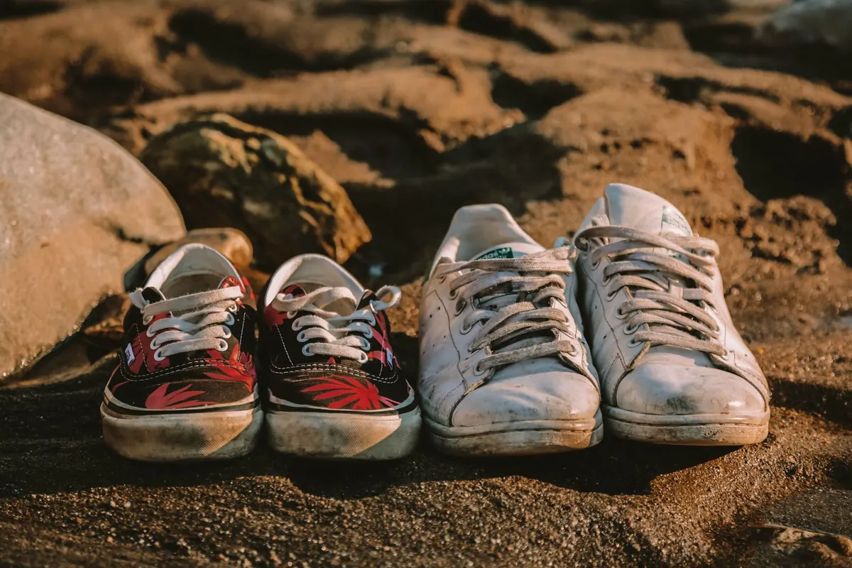 Baskets usées posées sur le sable, en illustration de « conseils pour devenir une vendeuse prospère »