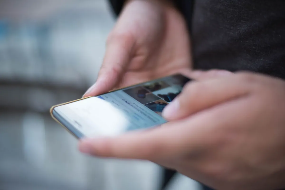 Mains tenant un smartphone, en illustration de « devenir une vendeuse de confiance »