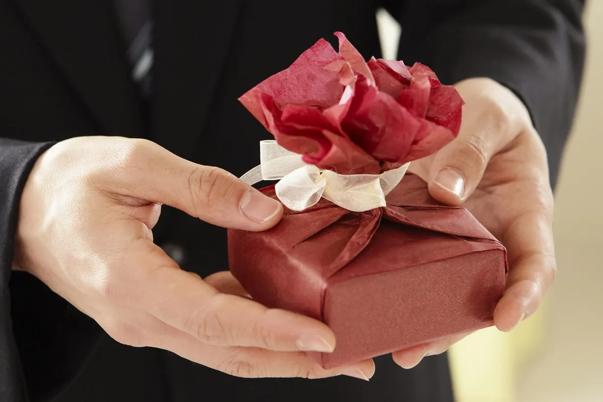 Mains tenant un paquet cadeau, en illustration de « envoyer des culottes au Royaume-Uni »