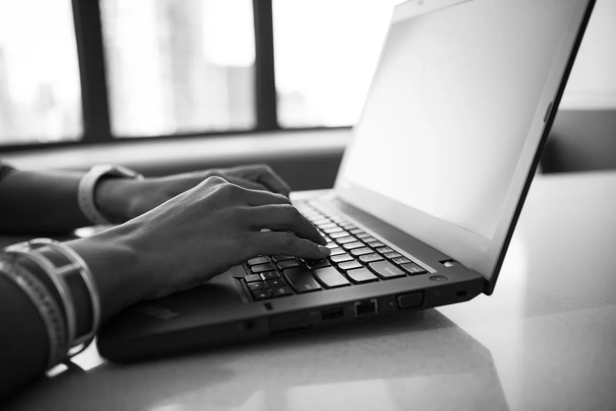 Mains sur un clavier en noir et blanc, en illustration de « Renee Ritz vendeuse »
