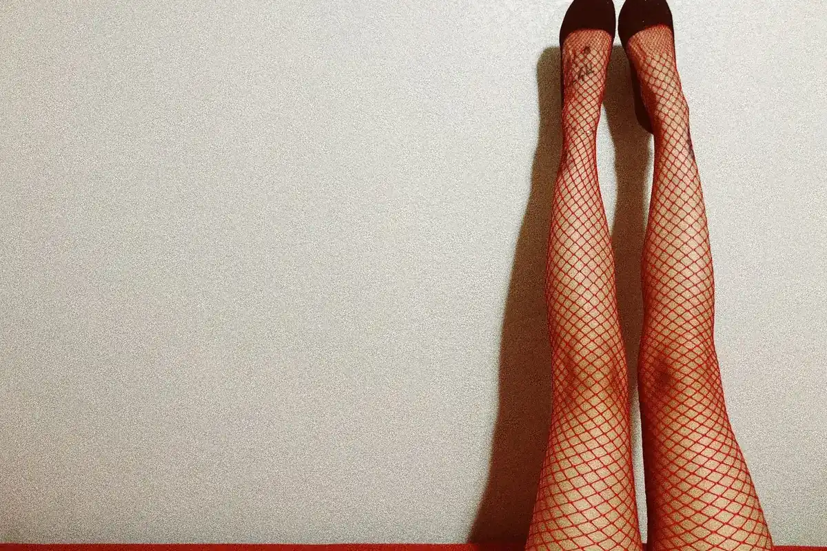 Jambes en bas résille contre un mur, en illustration de « repérer un gaspilleur de temps »