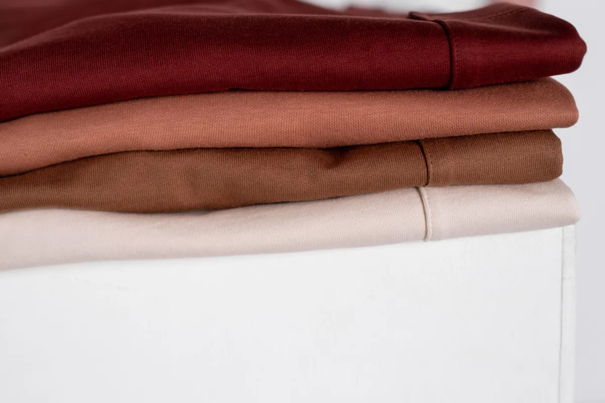 Vêtements pliés dans des tons rouges, en illustration de « vendeuses de culottes de la génération Z »