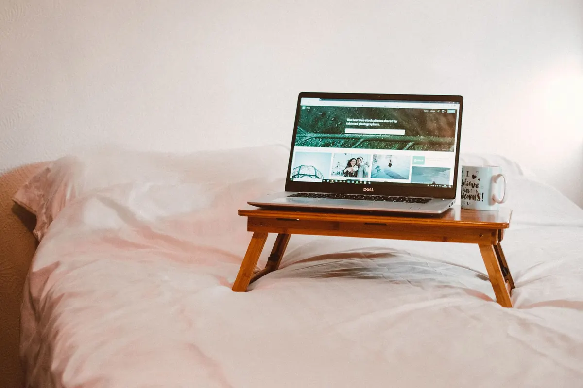 Ordinateur sur une table de lit, en illustration de « vendre des culottes en couple »
