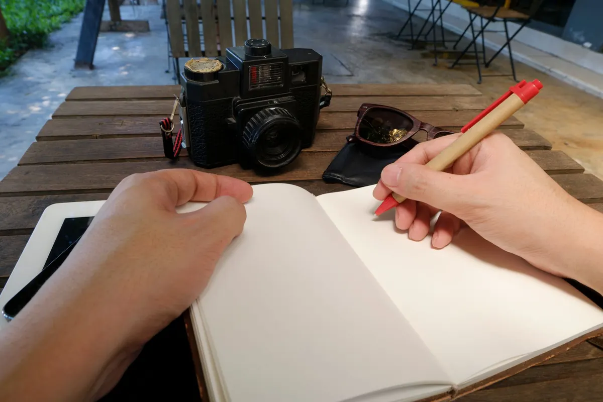 Carnet vierge et appareil photo, en illustration de « choses à savoir sur la vente de culottes en ligne »