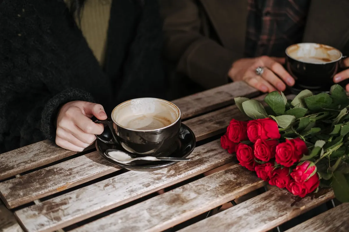 Café et roses rouges sur une table, en illustration de « rencontrer des femmes sur internet »