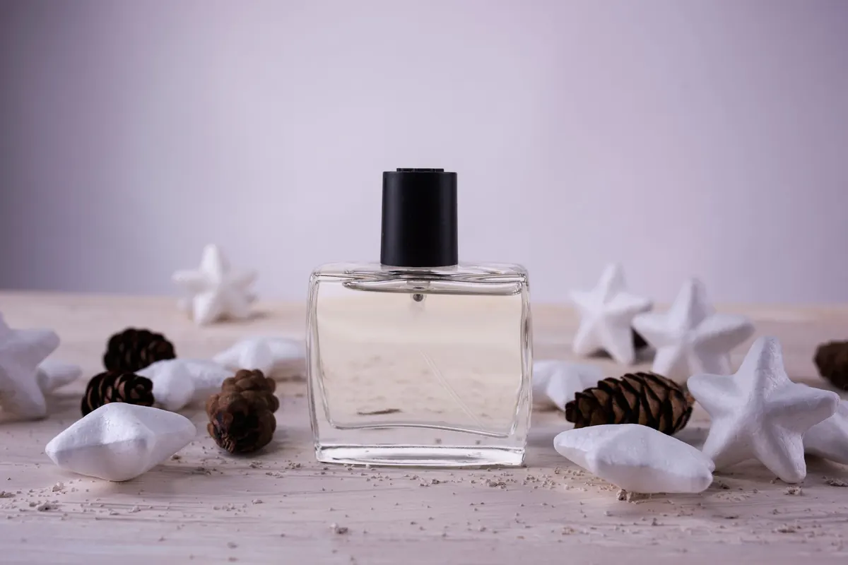 Flacon de parfum et pommes de pin, en illustration de « site vente culotte portée particulier »