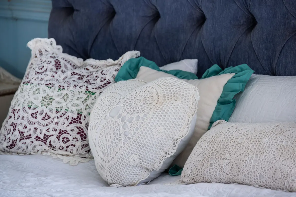 Coussins brodés sur un lit, en illustration de « acheter culotte portée »