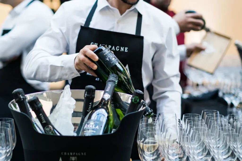 Serveur versant du champagne lors d'un événement formel, élégance et luxe.