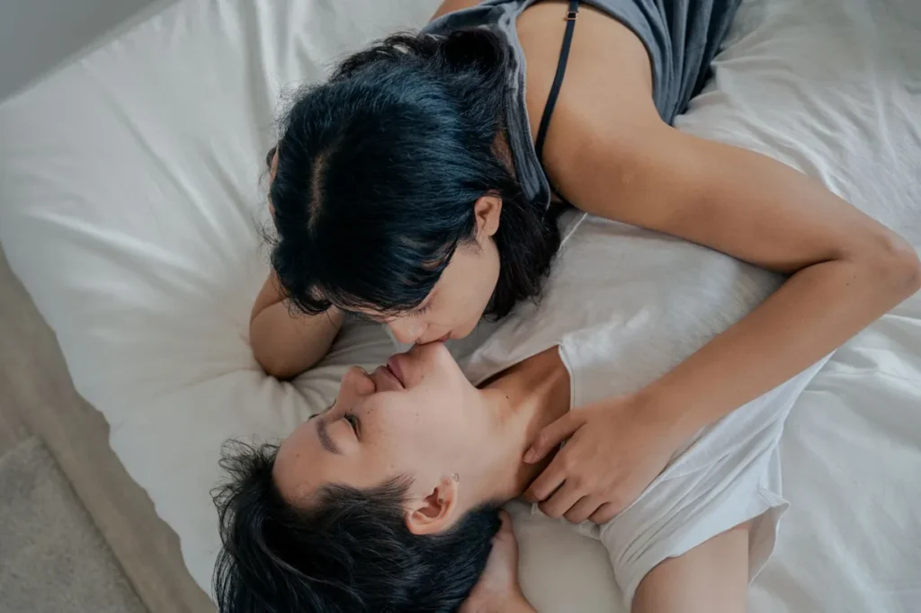 Un couple amoureux partage un moment intime allongé sur un lit