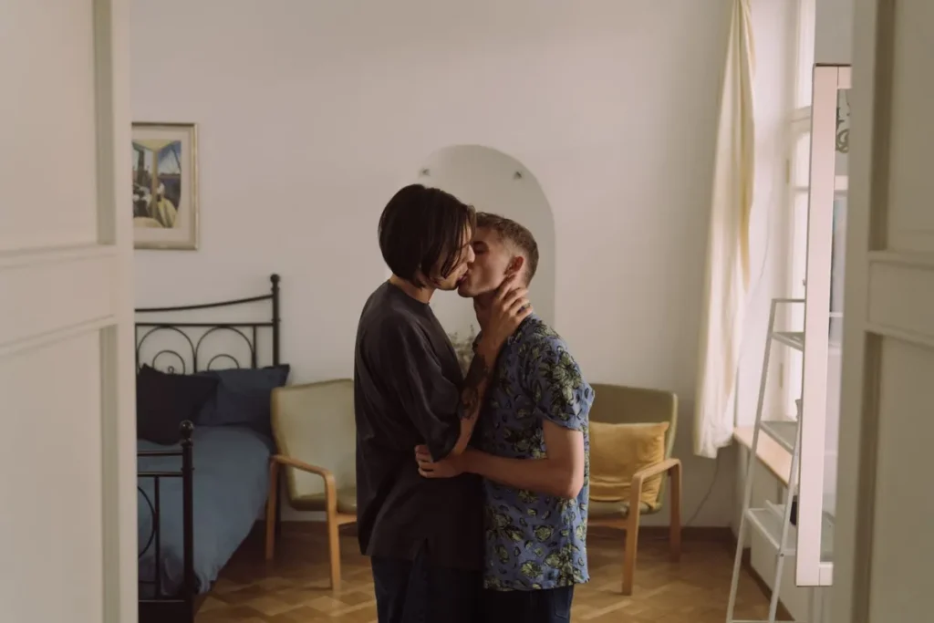 Un couple s'enlace tendrement dans une chambre élégante, évoquant l'amour