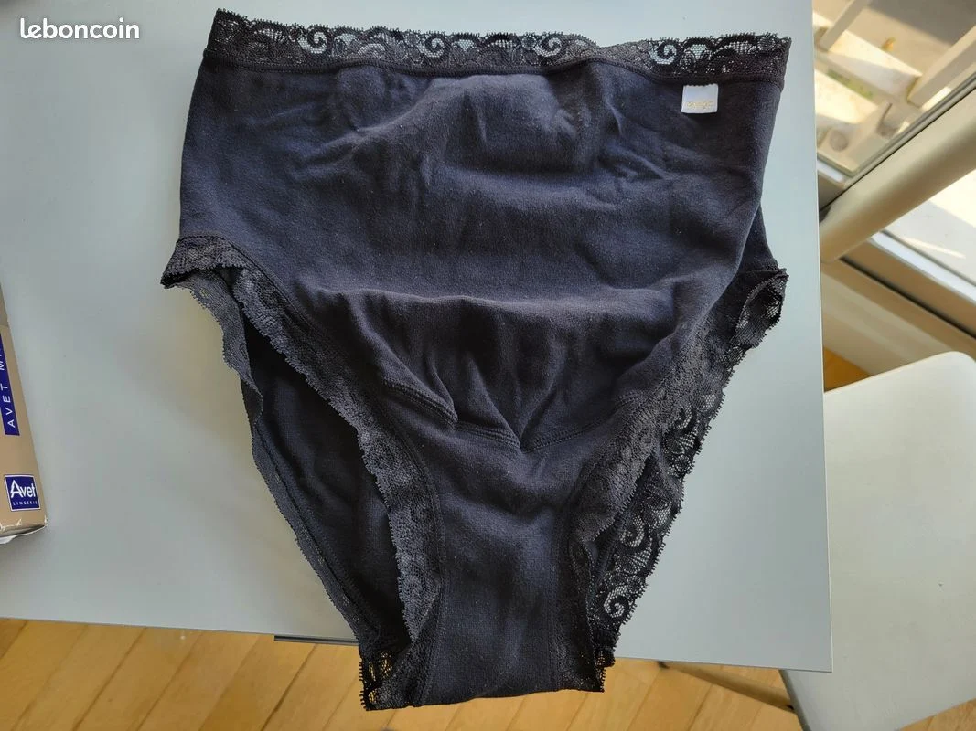 Culotte en dentelle noire posée à plat, préparée pour une annonce de culotte portée