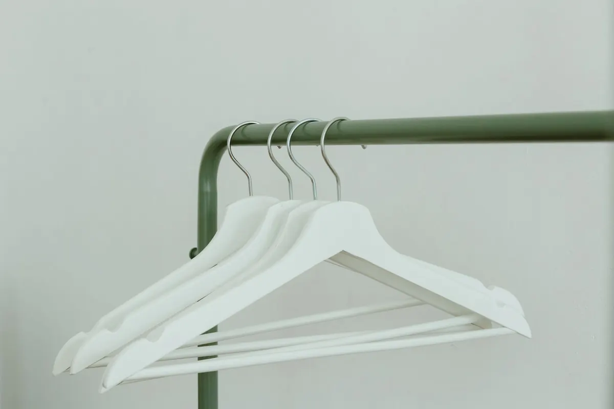 Cintres blancs sur un portant, image d'illustration : site pour vendre ses culottes