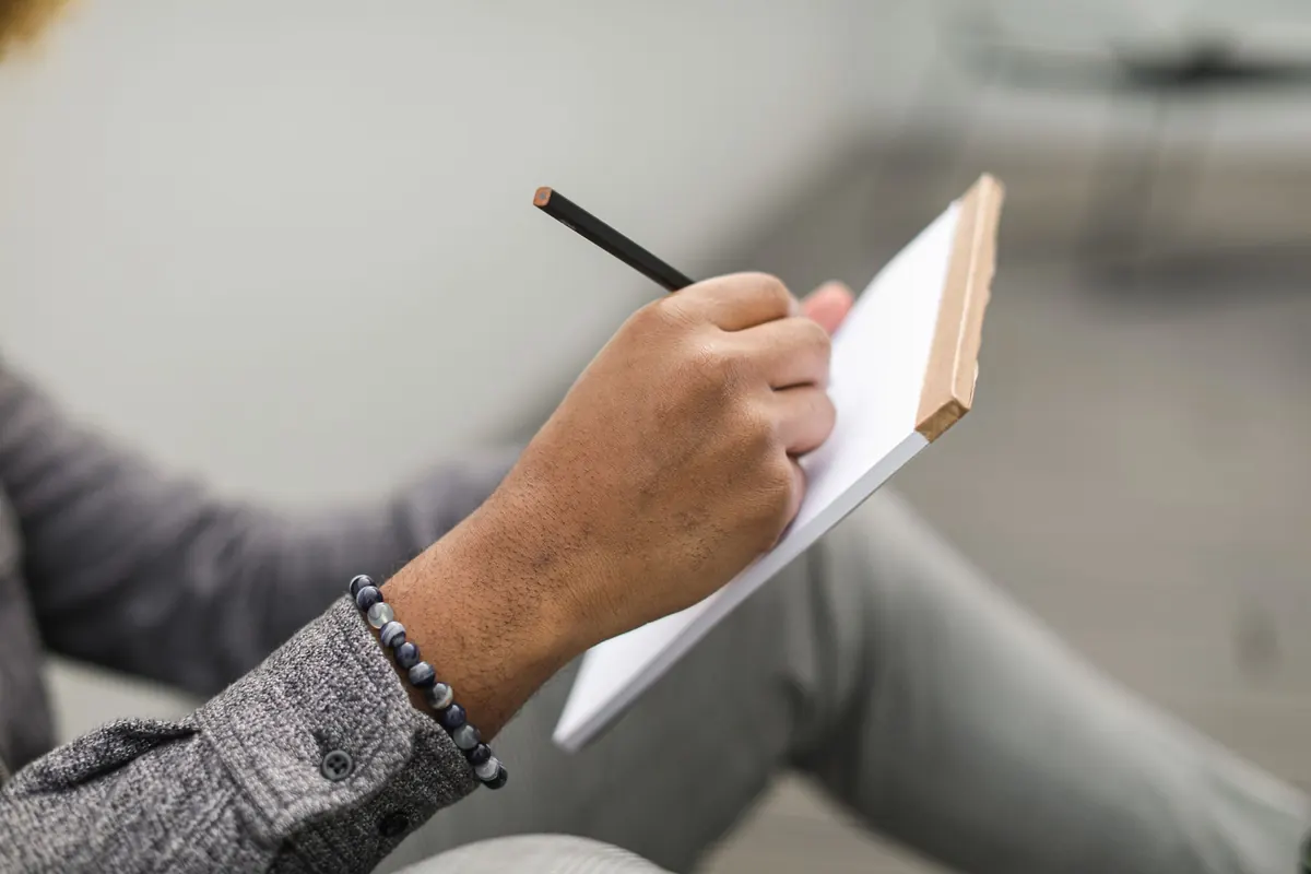 Main qui écrit sur un bloc-notes, en illustration de « vendre culotte portée légal »